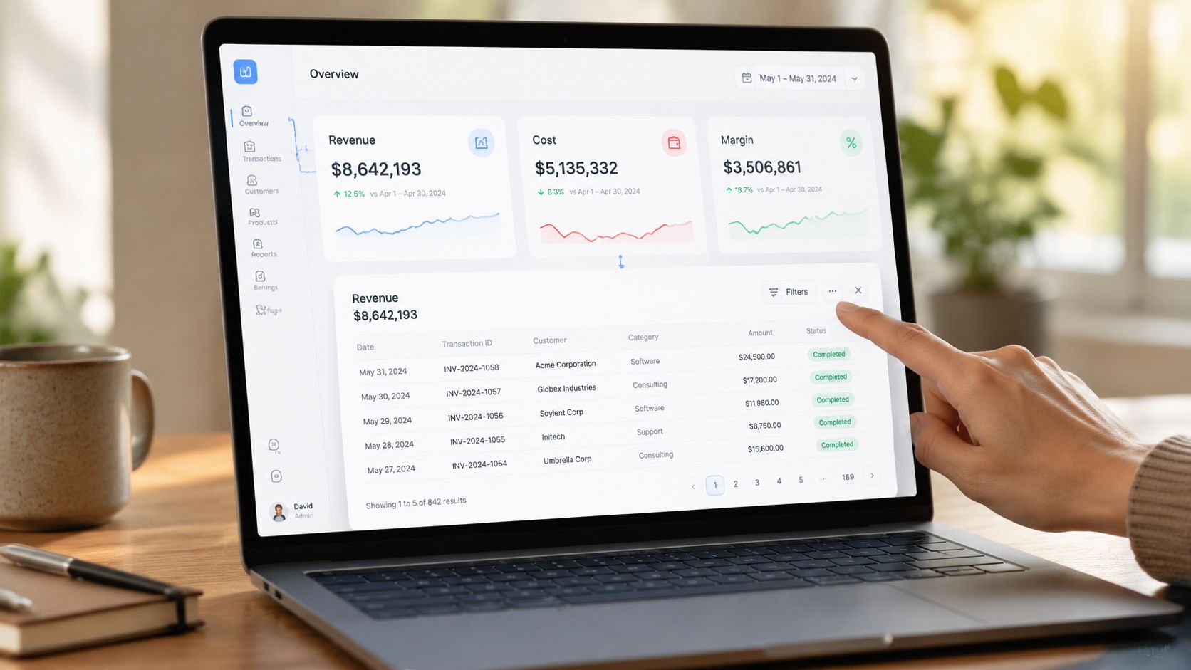 A user interacting with a data visualization dashboard on a laptop displaying revenue, costs, and transaction history.